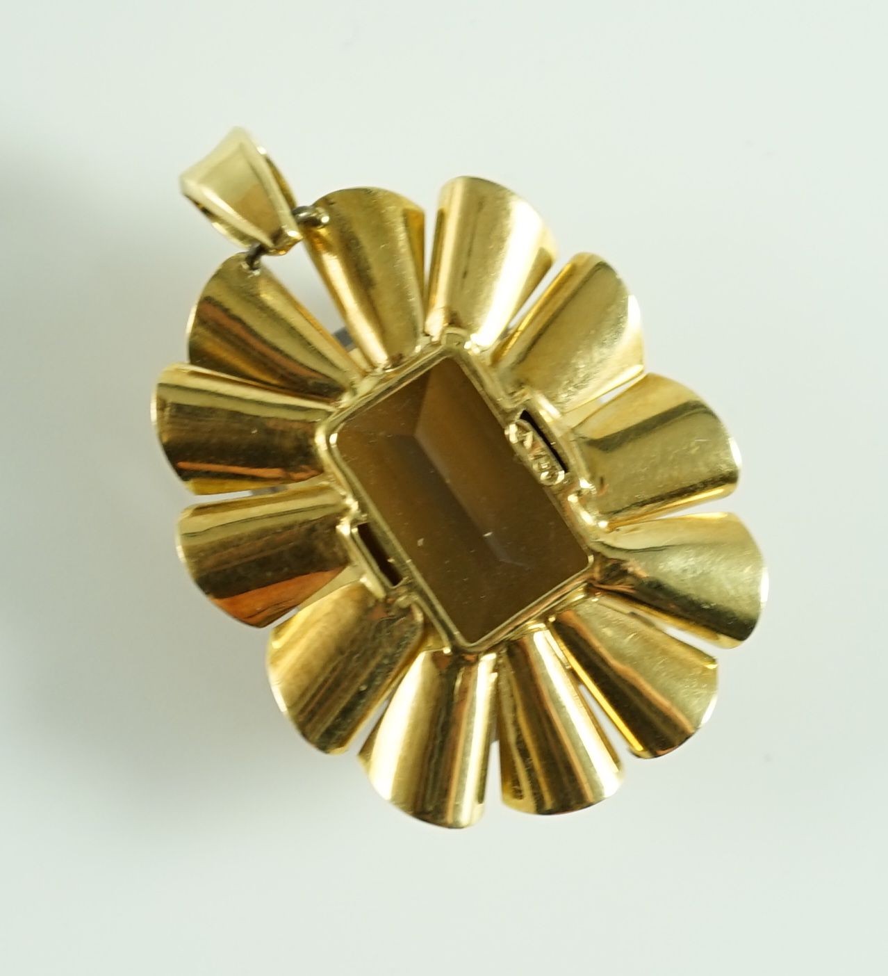 A modern 750 gold, emerald cut smoky quartz and diamond chip set oval pendant